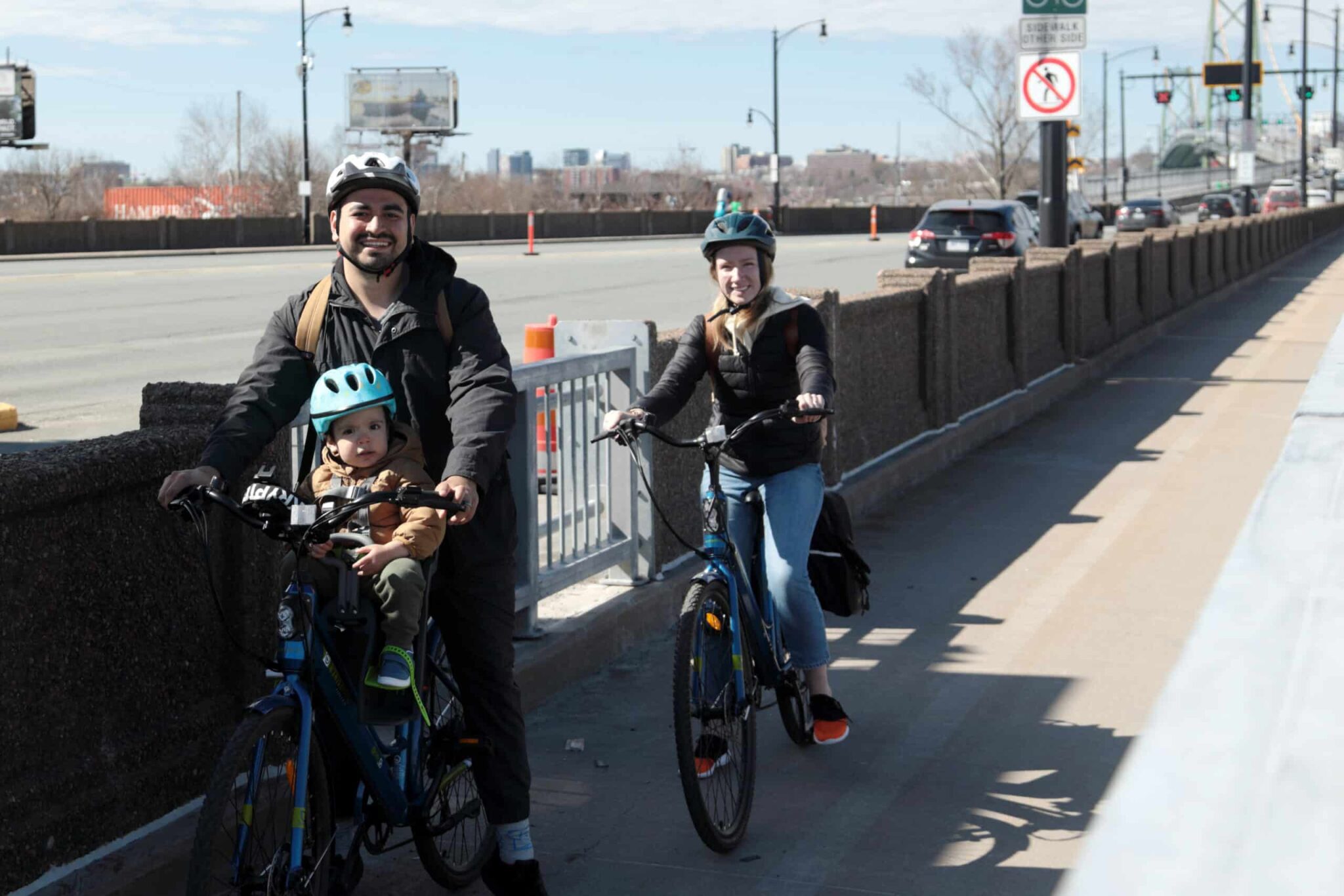 A family with a child ride their bikes in the Macdonald Bridge bike lane.