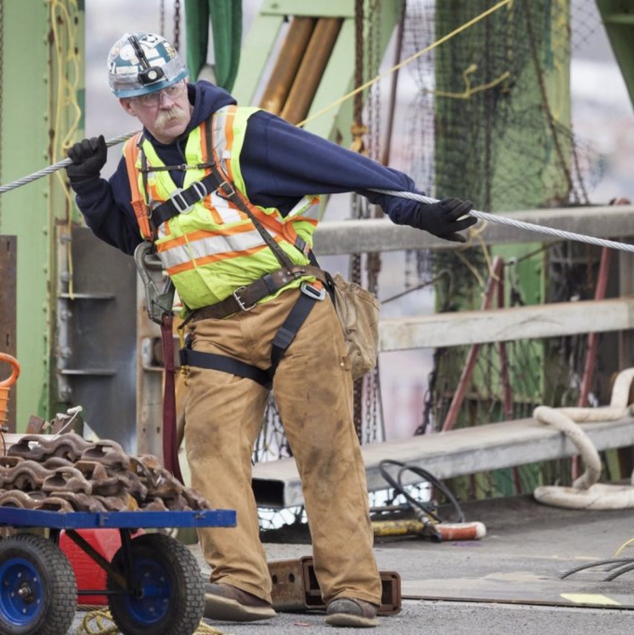 A worker maneuvers cable on the Macdonald Bridge.