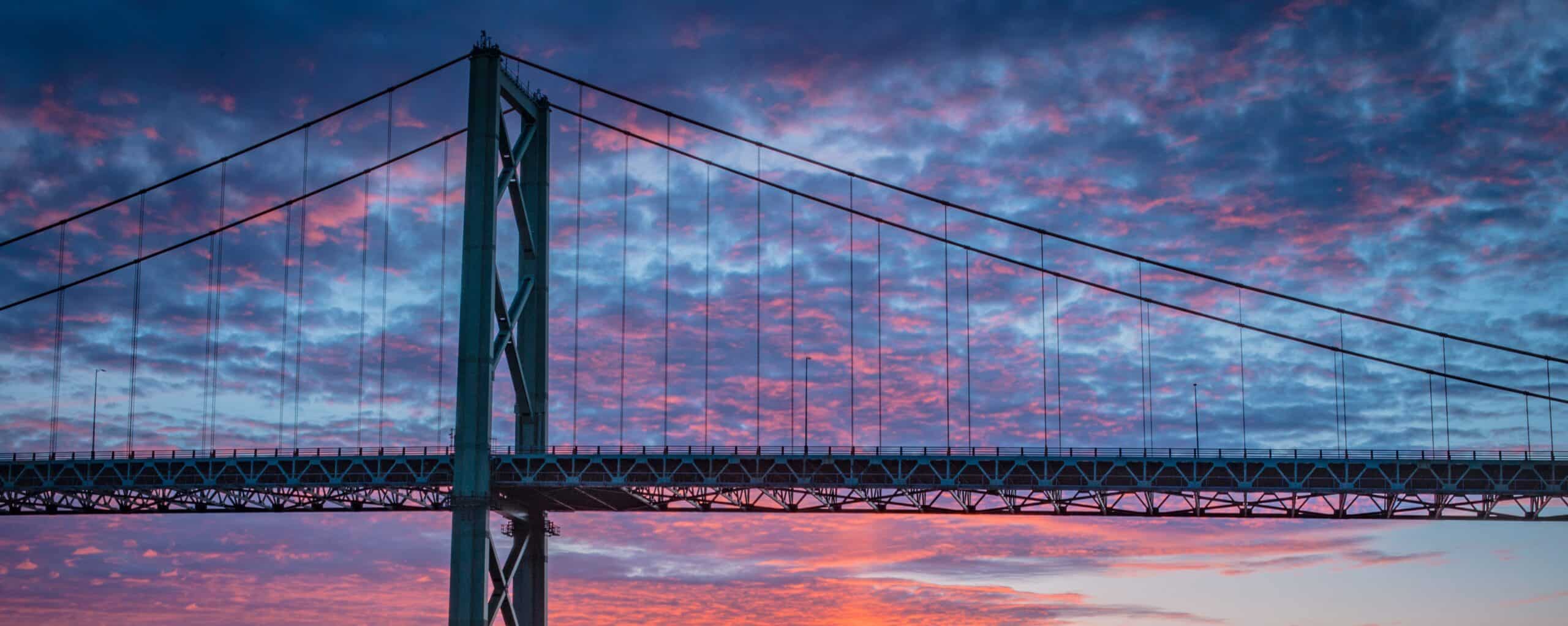 The MacKay Bridge is pictured against a colourful sky at sunset.