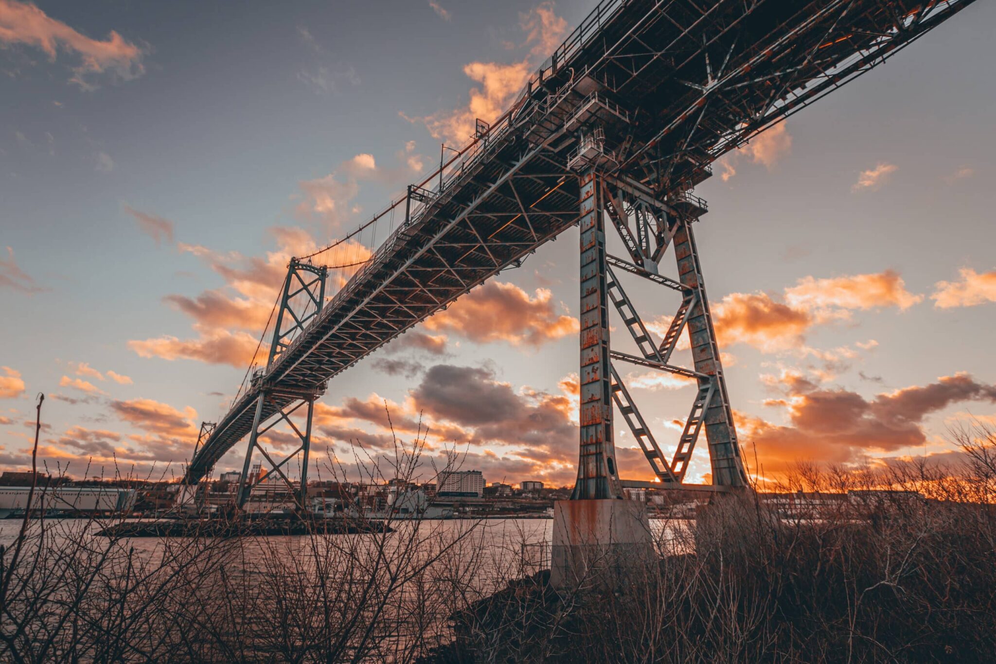 The Macdonald Bridge in Halifax is seen from underneath at sunset.